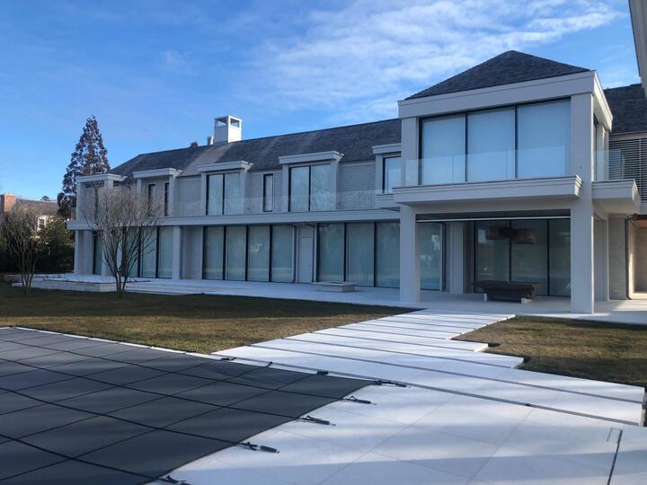 Contemporary home with window walls and a glass balcony